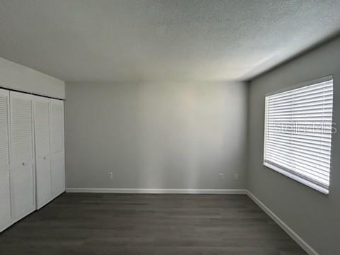 283 Gardner Lane, Unit D Kissimmee, FL 34743 - Photo 10 of 12 a view of an empty room with wooden floor and a window