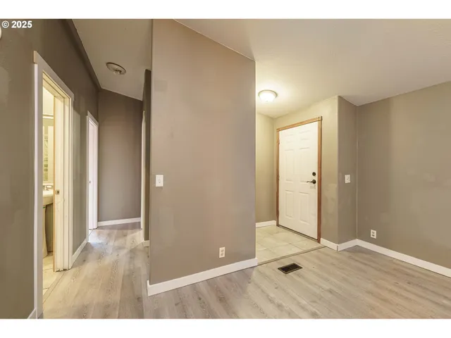 a view of an empty room with wooden floor