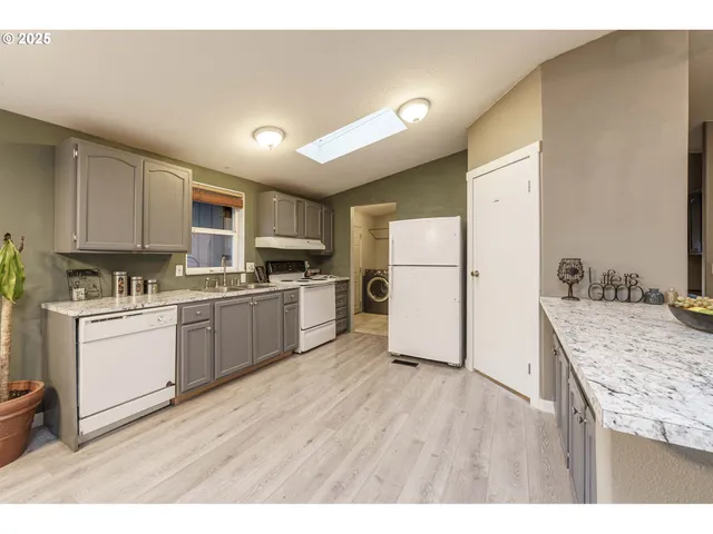 a kitchen with a refrigerator a stove top oven and a center island