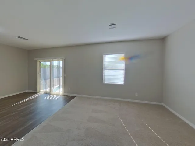 a view of empty room with kitchen and window