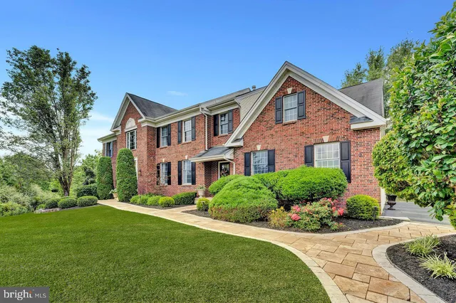 a front view of a house with a yard and potted plants
