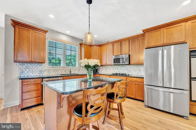 a kitchen with stainless steel appliances granite countertop wooden floors and sink