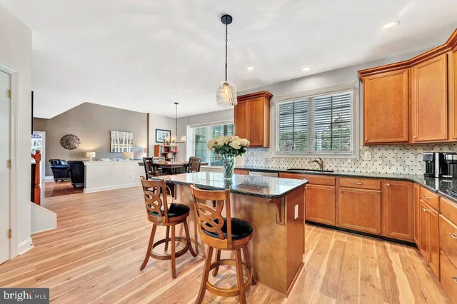 a kitchen with granite countertop wooden cabinets a counter top space and stainless steel appliances