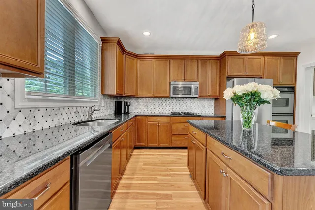 a kitchen with stainless steel appliances granite countertop counter space and wooden floor