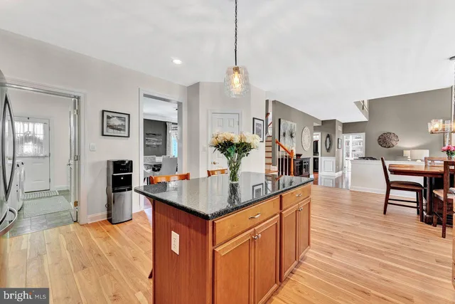 a view of a dining room and livingroom with furniture wooden floor a rug and a chandelier