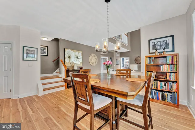 a kitchen with stainless steel appliances wooden floor dining table and chairs