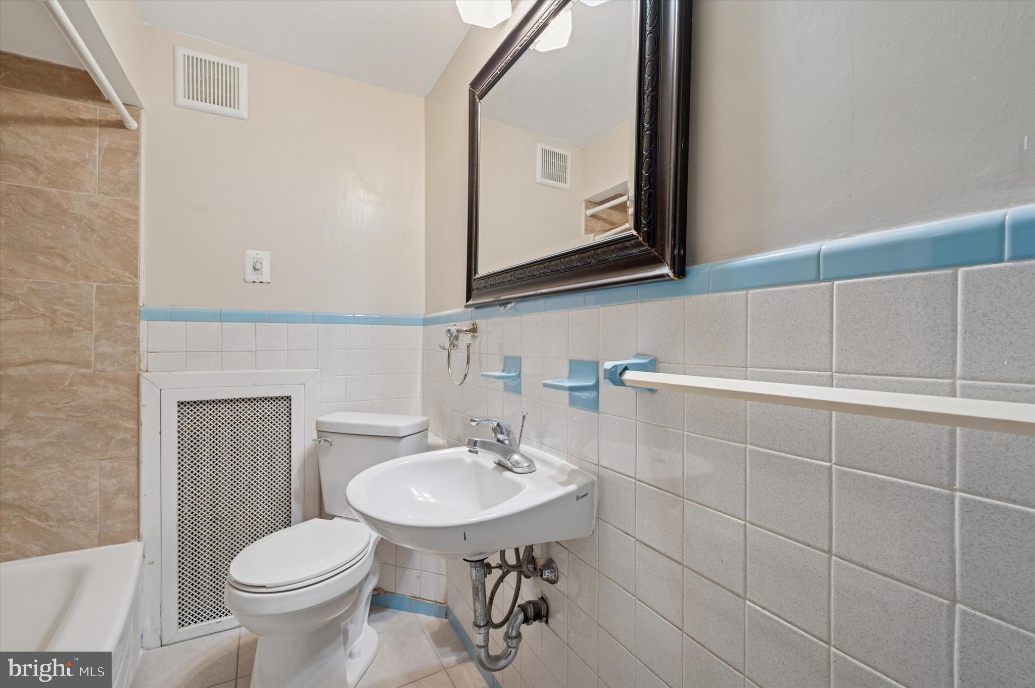 913 Tasker Street Philadelphia, PA 19148 - Photo 12 of 22 a bathroom with a toilet a sink and mirror