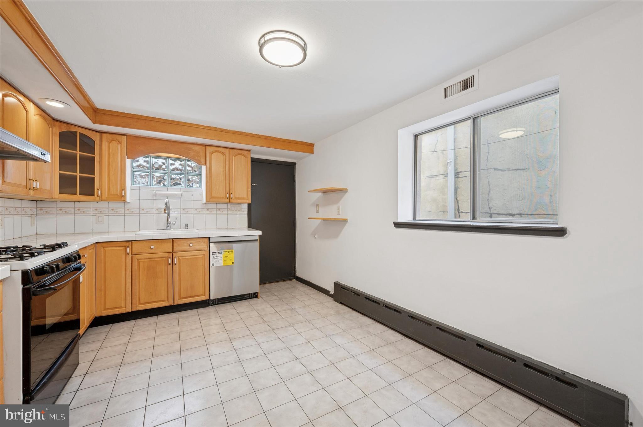 913 Tasker Street Philadelphia, PA 19148 - Photo 21 of 22 a kitchen with granite countertop a stove a sink and a granite counter tops