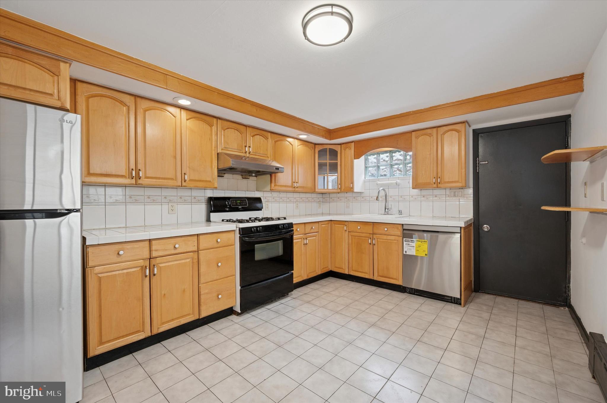 913 Tasker Street Philadelphia, PA 19148 - Photo 5 of 22 a kitchen with stainless steel appliances granite countertop a stove sink and cabinets
