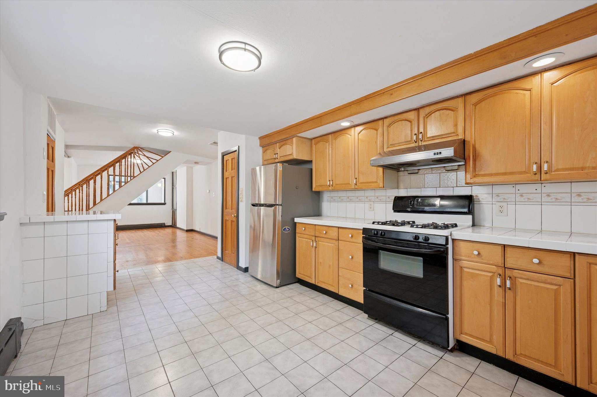 913 Tasker Street Philadelphia, PA 19148 - Photo 6 of 22 a kitchen with stainless steel appliances granite countertop a stove a sink and a refrigerator