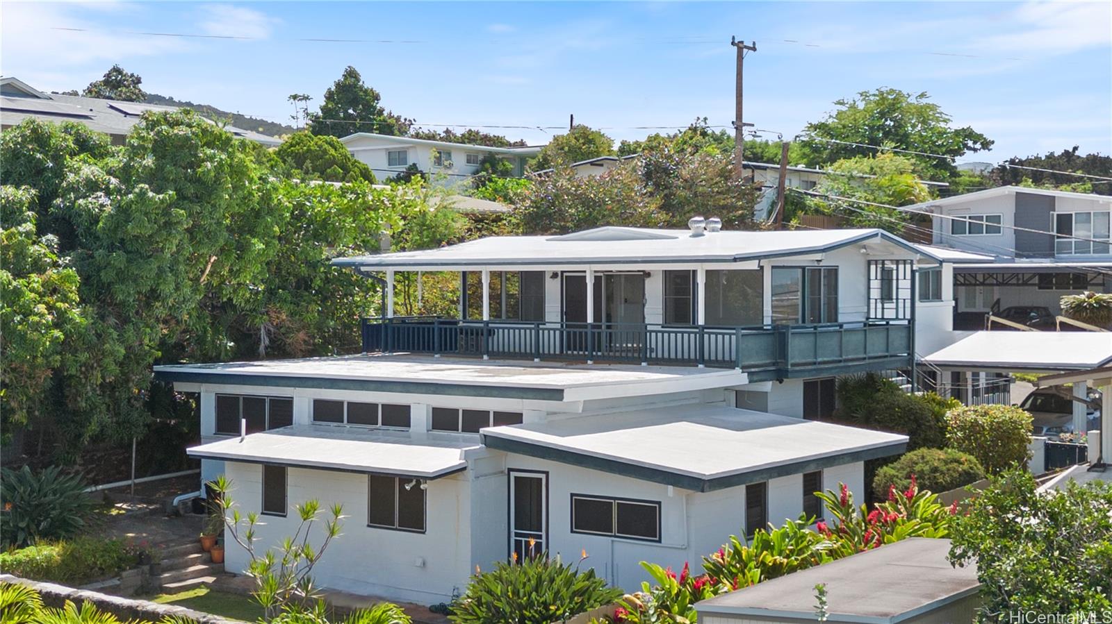 a front view of a house with a yard balcony and outdoor seating