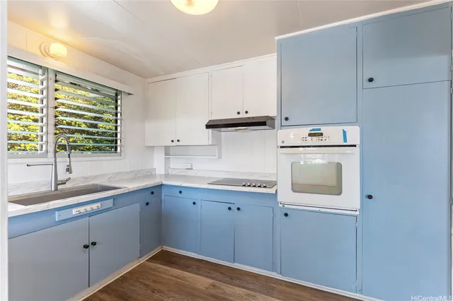 a kitchen with a sink a stove and cabinets