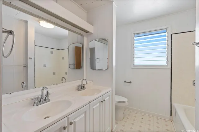 a bathroom with a double vanity sink mirror and toilet