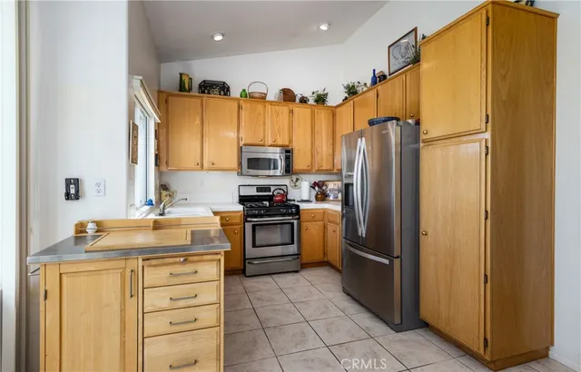 a kitchen with stainless steel appliances granite countertop a sink a stove a microwave and cabinets