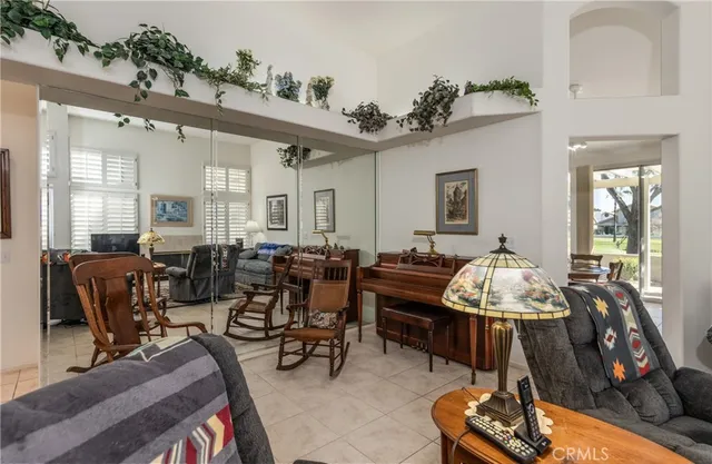 a living room with furniture kitchen view and a window