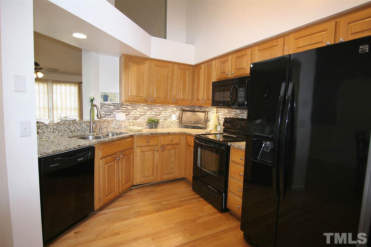 2301 Florida Court Raleigh, NC 27615 - Photo 7 of 20 a kitchen with granite countertop a refrigerator stove top oven and sink