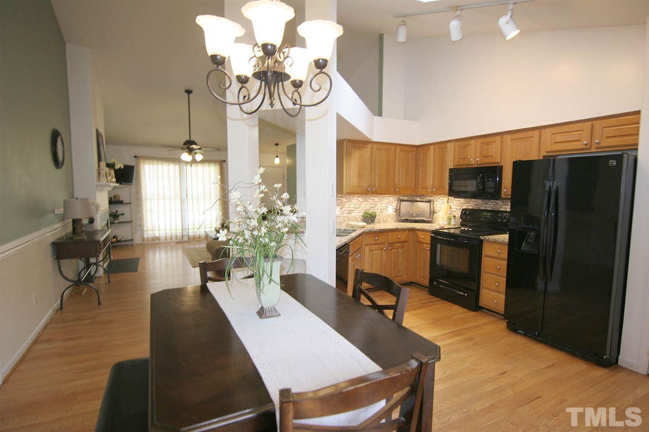 2301 Florida Court Raleigh, NC 27615 - Photo 10 of 20 a kitchen with stainless steel appliances granite countertop a refrigerator a sink dishwasher a stove a dining table and chairs with wooden floor