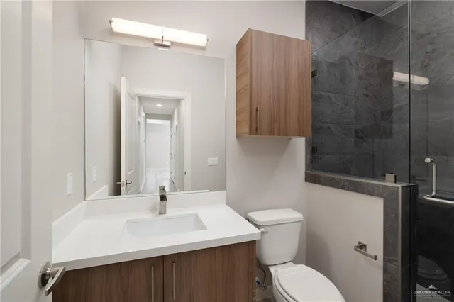 a bathroom with a sink a toilet and shower