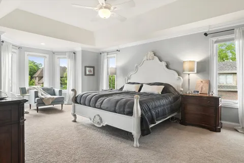 a spacious bedroom with a bed and large windows