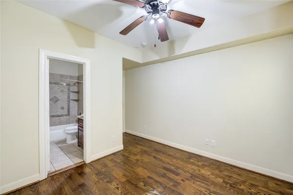 wooden floor in an empty room with a bathroom