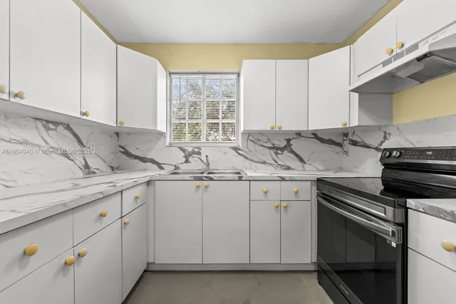 a kitchen with granite countertop white cabinets and white appliances