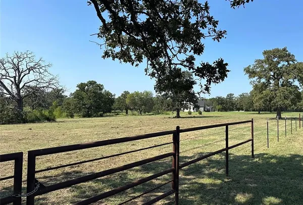 a view of a yard with wooden fence