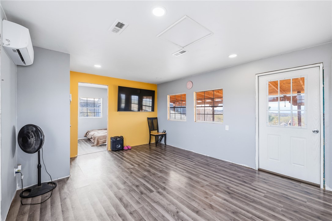 12241 South Robles Road Yucca, AZ 86438 - Photo 11 of 43 Unfurnished room featuring wood finished floors, a wall unit AC, and recessed lighting