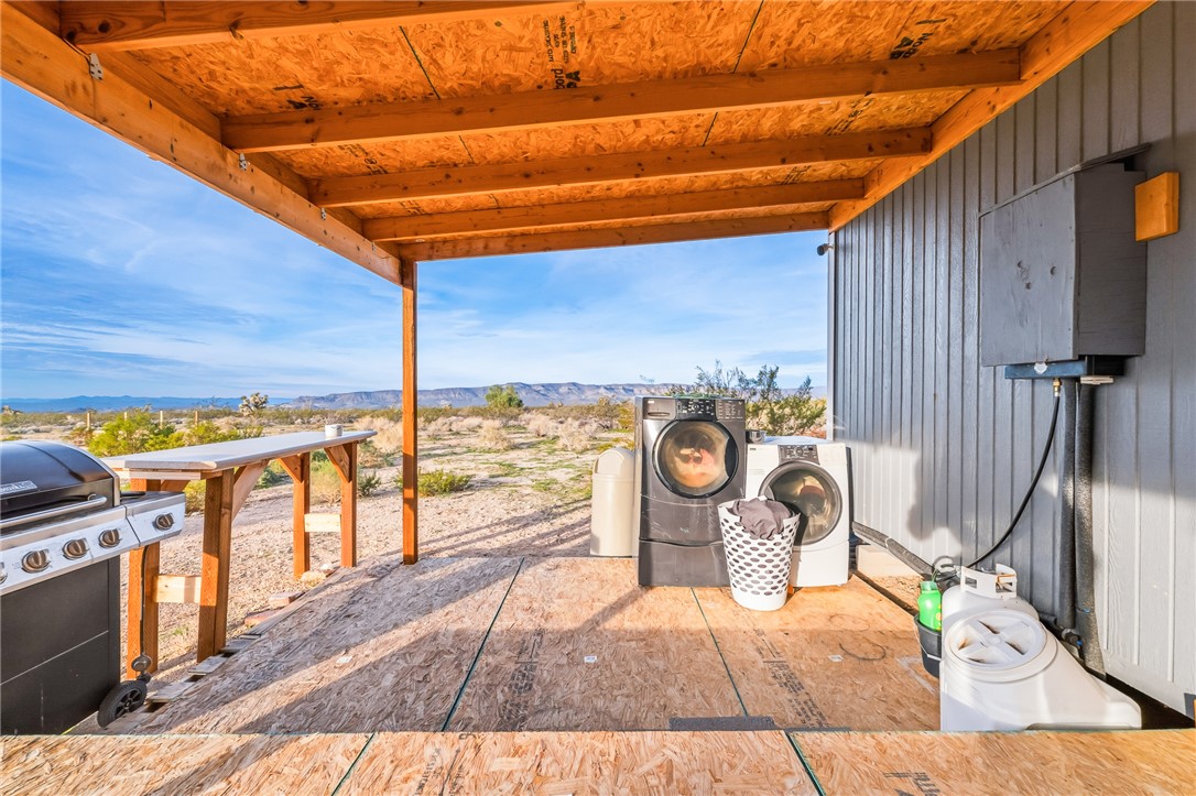 12241 South Robles Road Yucca, AZ 86438 - Photo 24 of 43 View of patio / terrace featuring a mountain view, washer and clothes dryer, and a grill