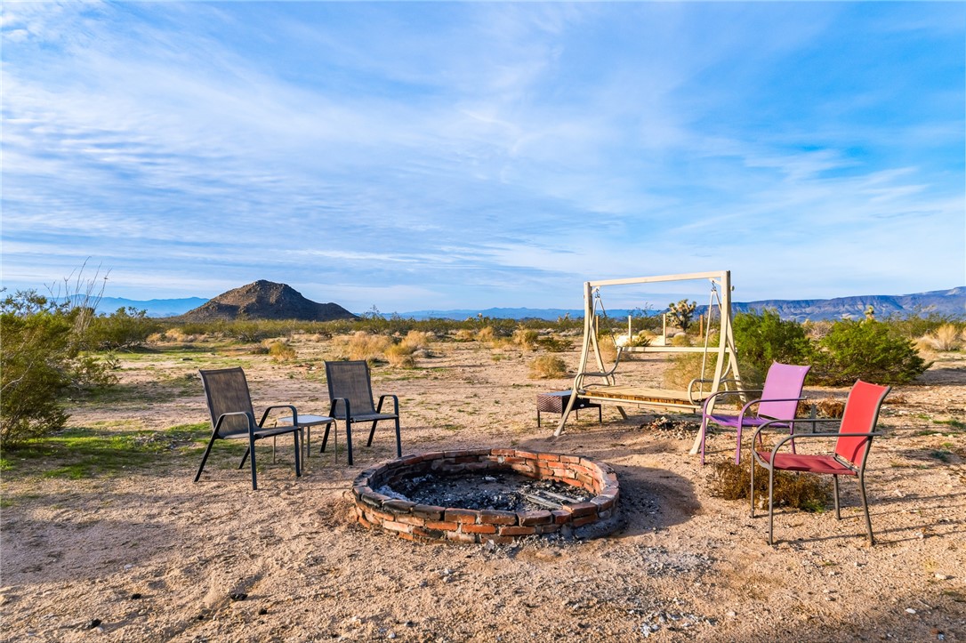 12241 South Robles Road Yucca, AZ 86438 - Photo 26 of 43 View of yard with an outdoor fire pit, a mountain view, and a patio area