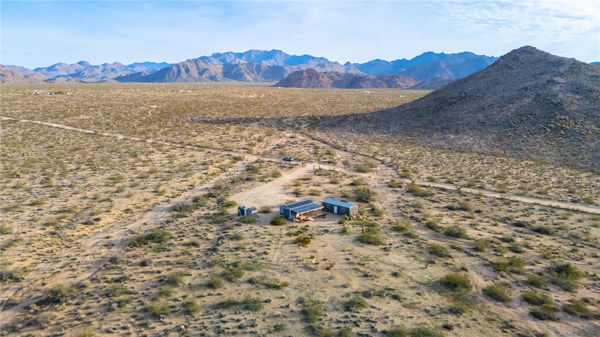 12241 South Robles Road Yucca, AZ 86438 - Photo 37 of 43 Aerial view of sparsely populated area with a mountain backdrop and a desert landscape