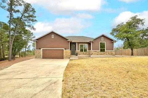 a front view of house with yard and trees around