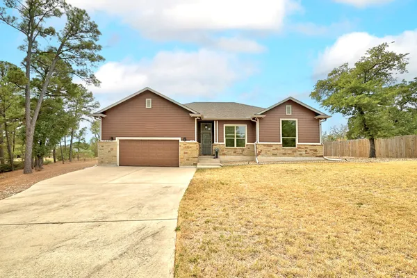 a front view of house with yard and trees around