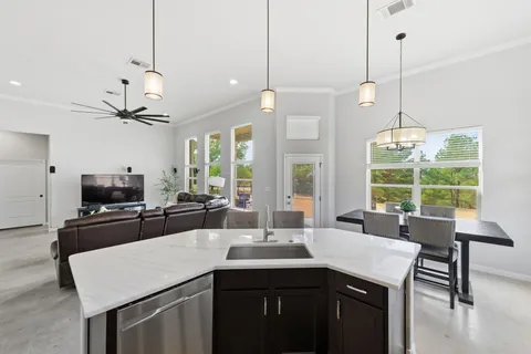a kitchen with kitchen island a sink dining table and chairs
