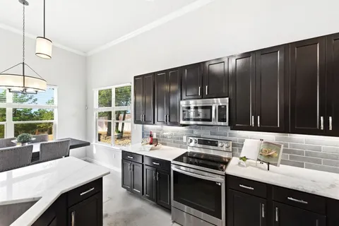 a kitchen with a stove sink and cabinets