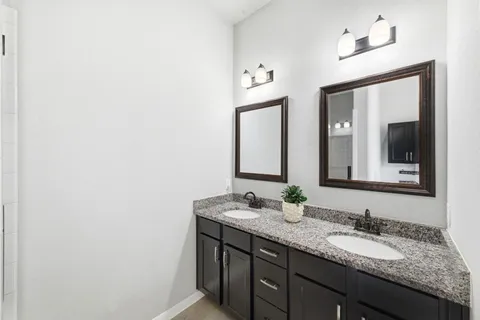 a bathroom with a granite countertop sink and a mirror