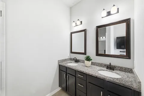 a bathroom with a granite countertop sink and a mirror