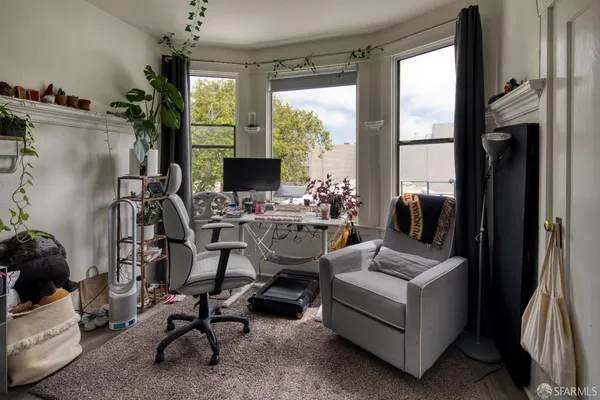 a view of a workspace with furniture and a window