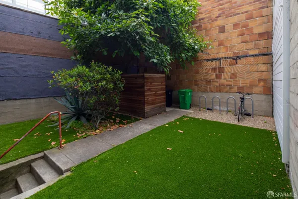 a view of a backyard with potted plants and large tree