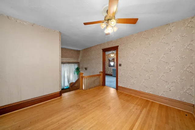 a view of an empty room with a window and wooden floor