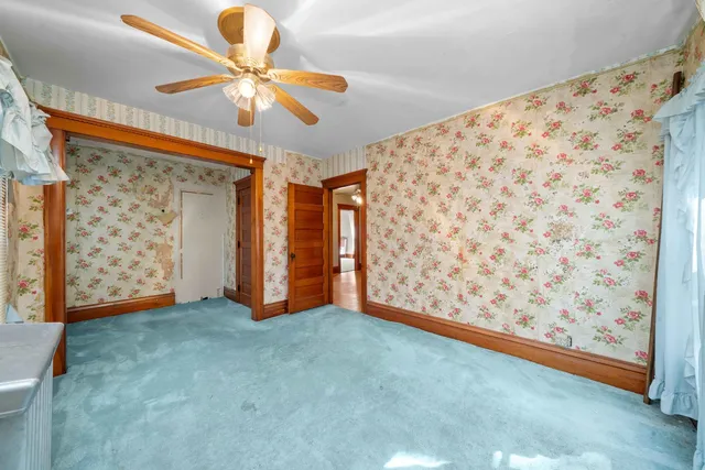 an empty room with wooden floor closet and windows