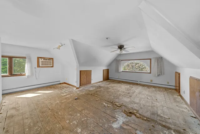 a view of an empty room with a window and a fireplace