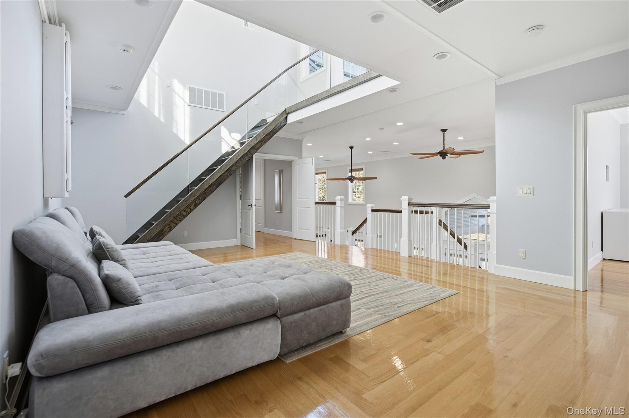 33 A Newtown Road Hampton Bays, NY 11946 - Photo 31 of 50 Living room featuring crown molding, recessed lighting, stairway, a skylight, and light wood-type flooring