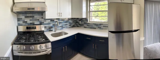 a kitchen with a stove a sink and a window