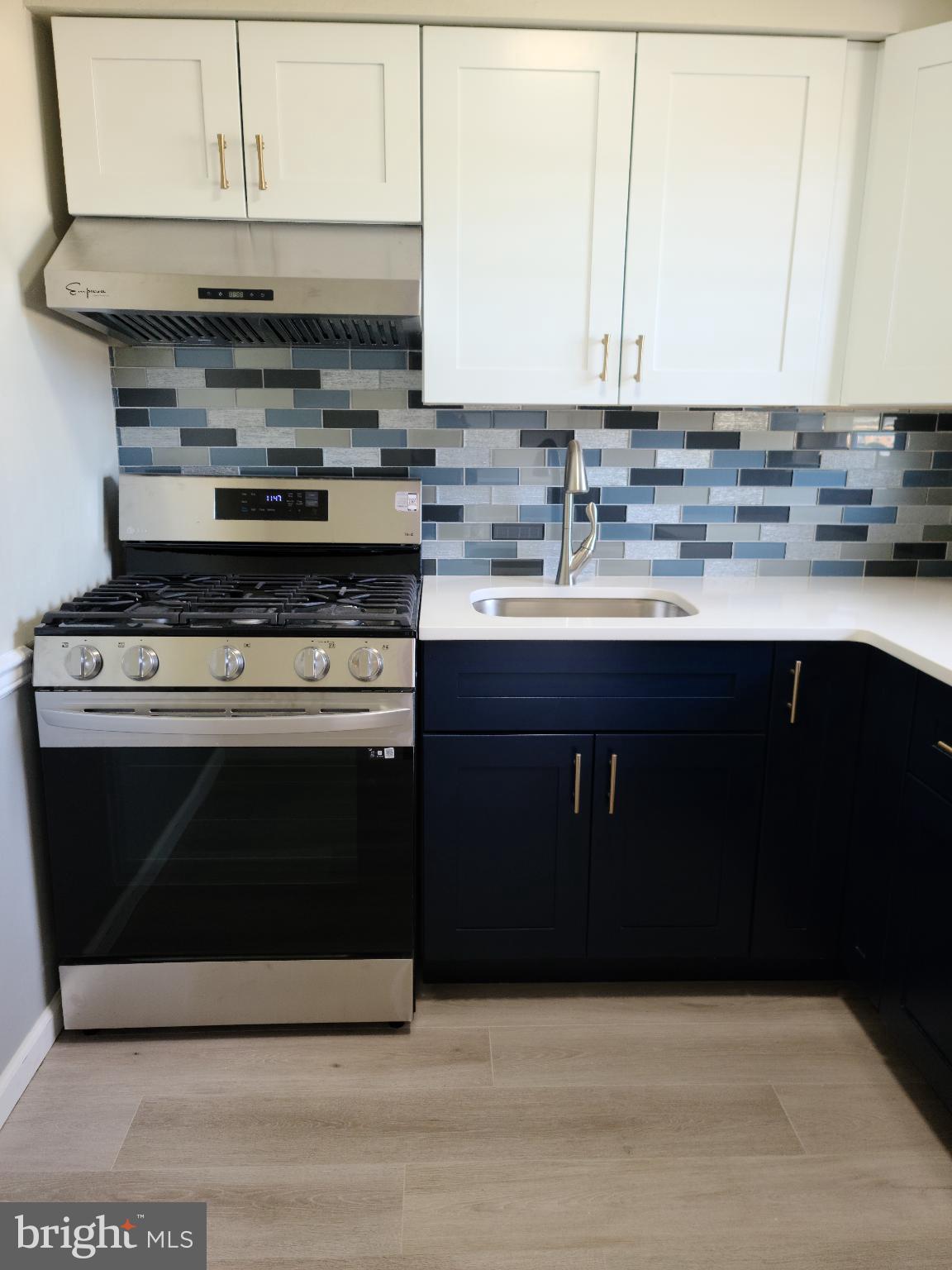 47 Garden View Terrace, Unit 4 East Windsor, NJ 08520 - Photo 8 of 12 a kitchen with stainless steel appliances a stove a sink and white cabinets
