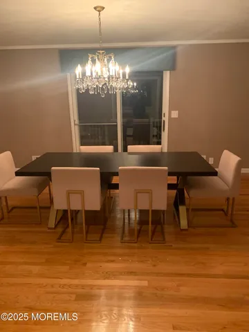 a view of a dining room with furniture and a chandelier