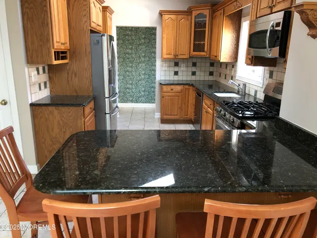 a kitchen with stainless steel appliances granite countertop a sink stove and cabinets