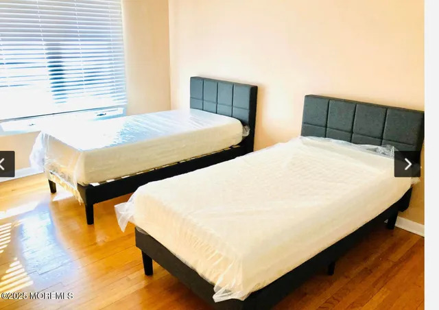 a bedroom with two beds and chair