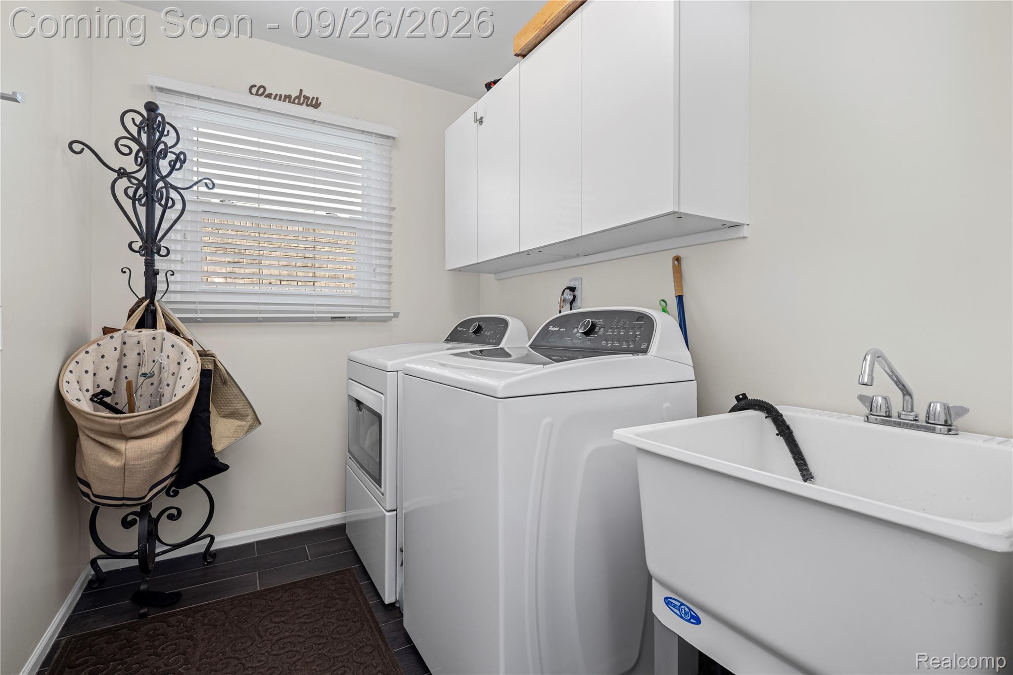7021 Fox Path Canton, MI 48187 - Photo 27 of 59 Laundry room featuring a utility sink, white upper cabinetry, and dark tile flooring