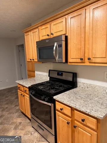 a kitchen with stainless steel appliances granite countertop a stove and a microwave
