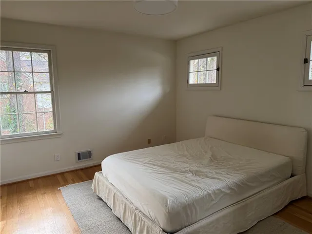 a bed sitting in a bedroom next to a window